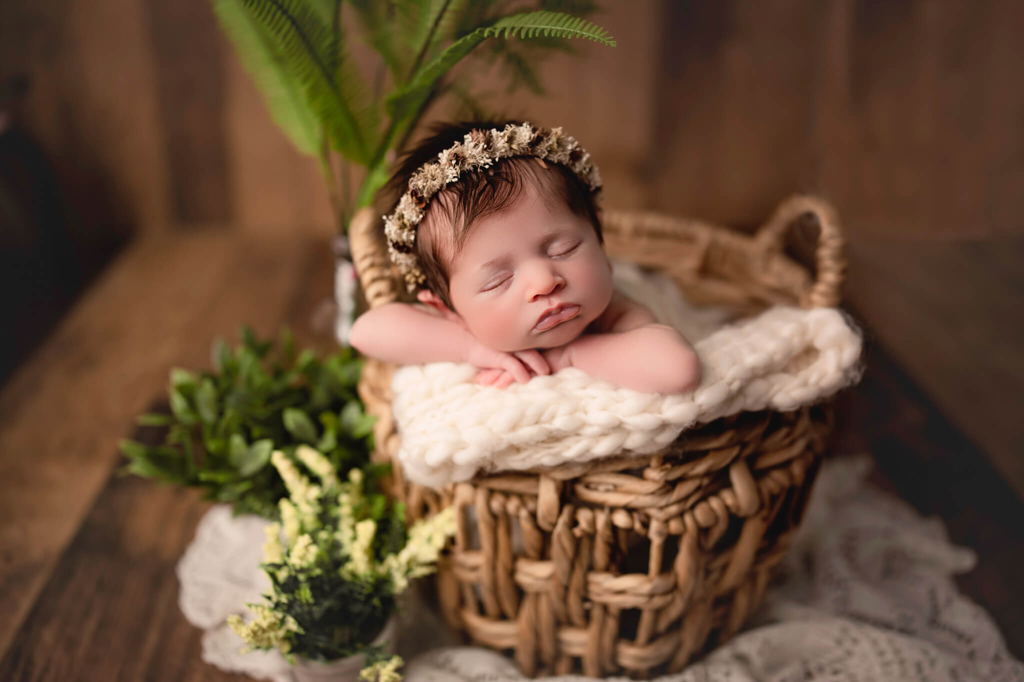 newborn photographer takes photo of baby in bamboo basket for hamilton baby store shoot