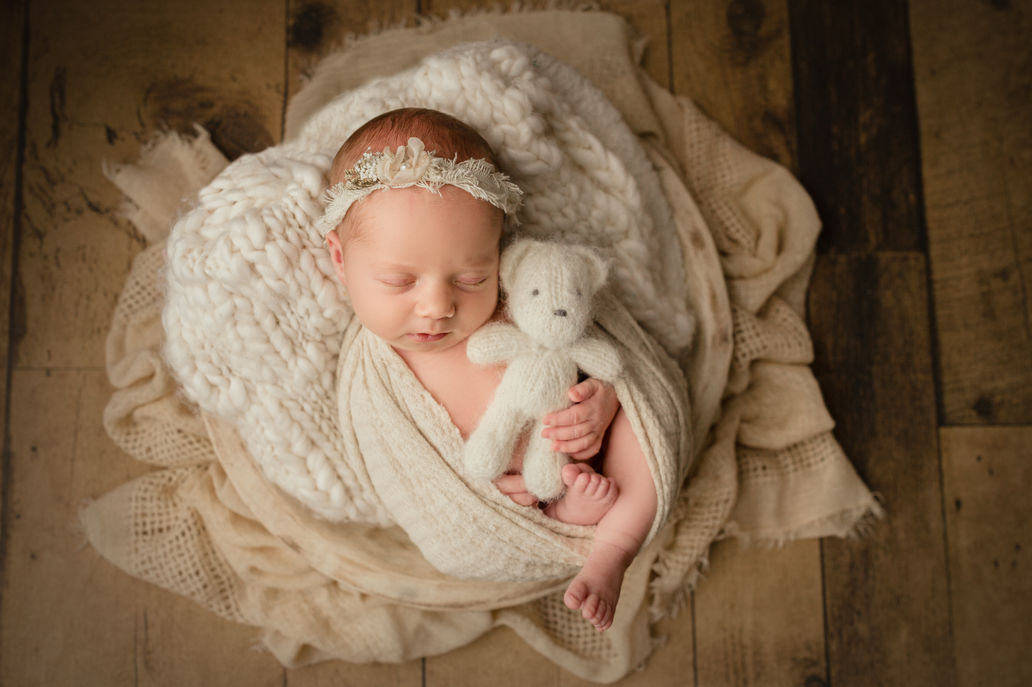 baby girl poses with small stuffed bear during burlington snuggle bugz ad shoot